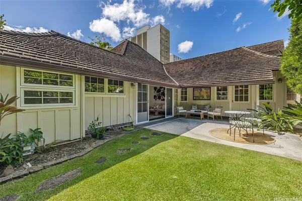 a view of a house with backyard and sitting area