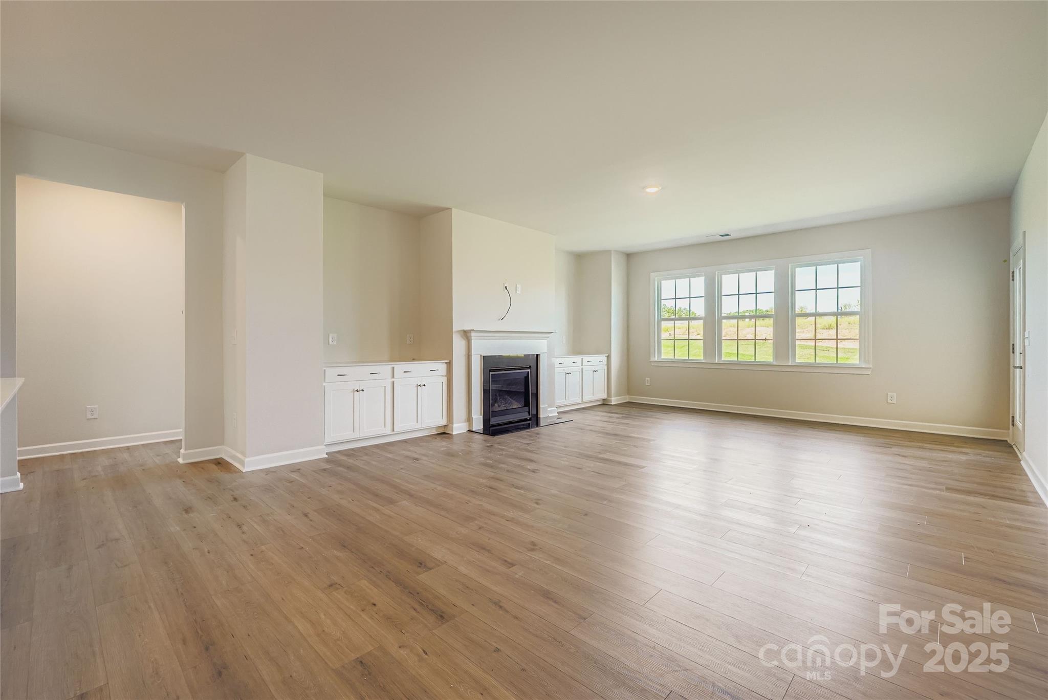 2244 Moon Crst Road Lancaster, SC 29720 - Photo 4 of 17 an empty room with wooden floor and fireplace