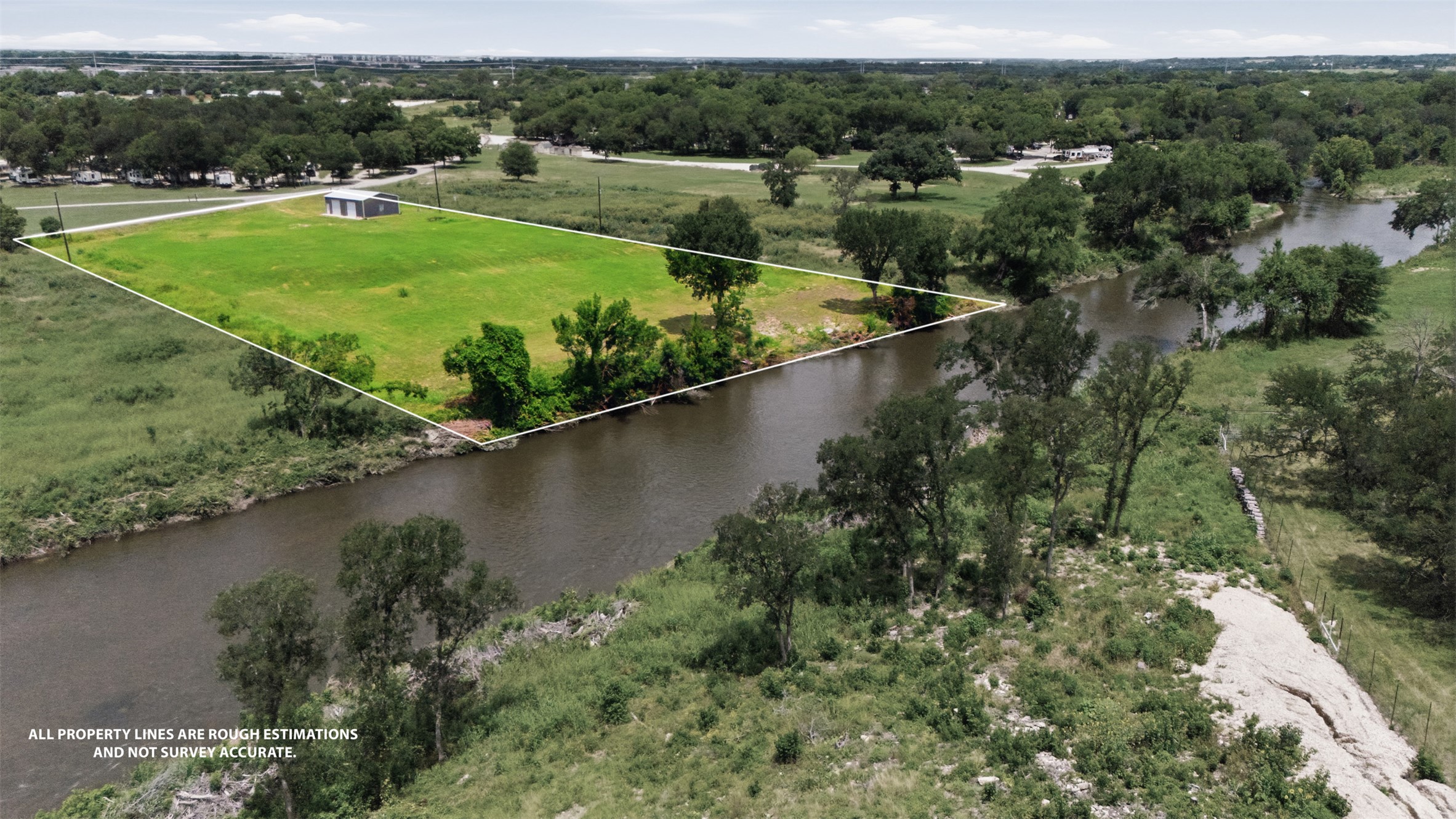 2043 Fm 971 Georgetown, TX 78626 - Photo 2 of 12 A tranquil riverfront parcel awaits your vision, boasting verdant landscapes and a private shed.