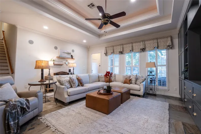 a living room with furniture a flat screen tv and a large window