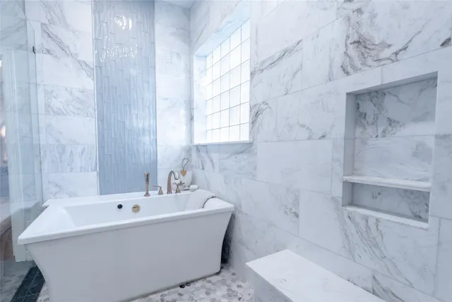 a white bath tub sitting in a bathroom next to a sink