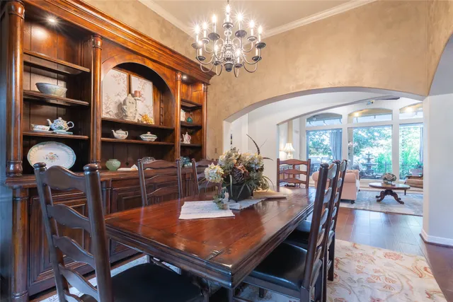 a dining room with furniture a chandelier and wooden floor