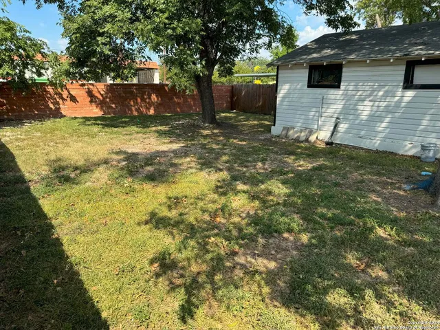 a backyard of a house with barbeque oven