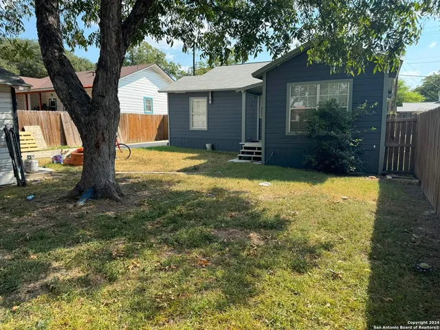 a view of backyard of house with green space