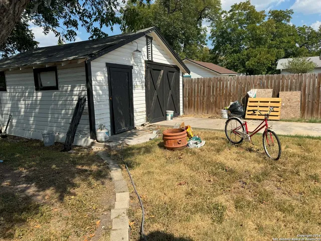 a view of a chair and table in backyard of the house