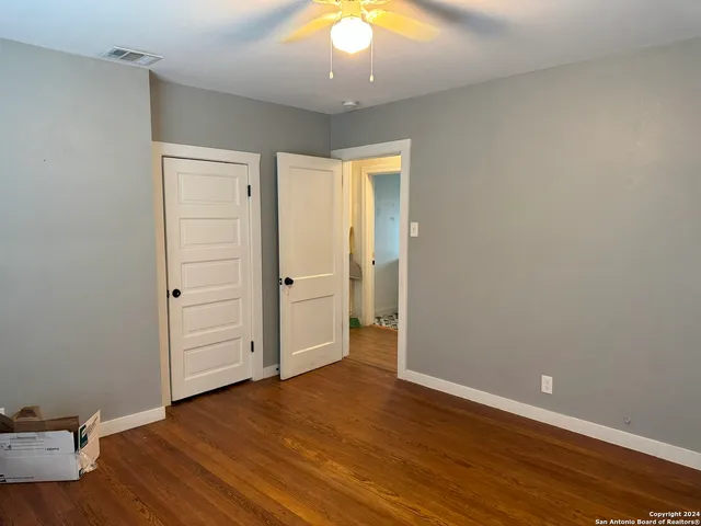 an empty room with wooden floor and closet