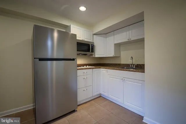 a kitchen with a refrigerator sink and cabinets