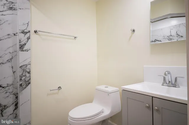 a bathroom with a toilet a sink and mirror