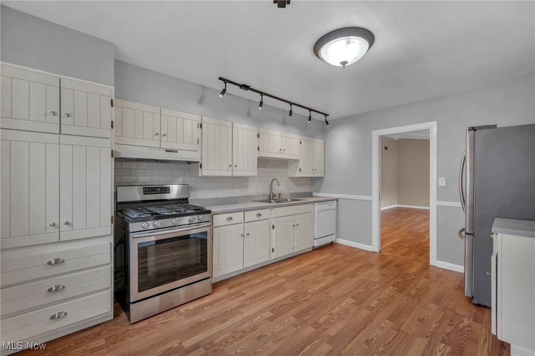 267 Barrett Road Berea, OH 44017 - Photo 16 of 41 Kitchen featuring sink, stainless steel appliances, tasteful backsplash, light hardwood / wood-style flooring, and white cabinets