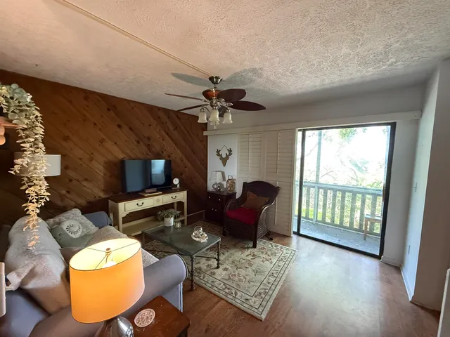 a living room with furniture a fireplace and a floor to ceiling window