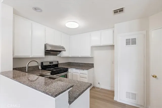 a kitchen with a sink a stove and cabinets