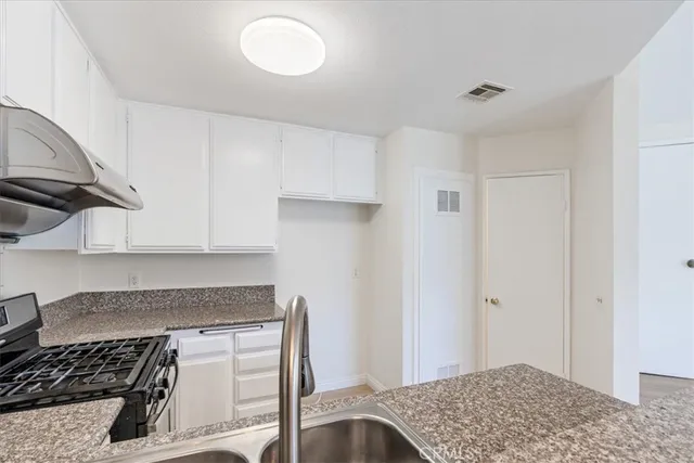 a kitchen with a stove and a white cabinet