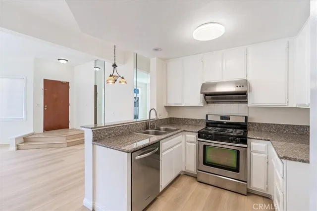 a kitchen with granite countertop a sink stove and microwave
