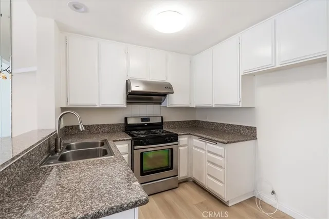 a kitchen with sink a stove and cabinets