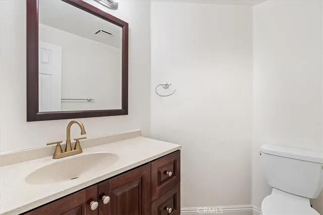 a bathroom with a sink vanity and a toilet