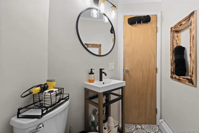 a bathroom with a sink toilet and a mirror