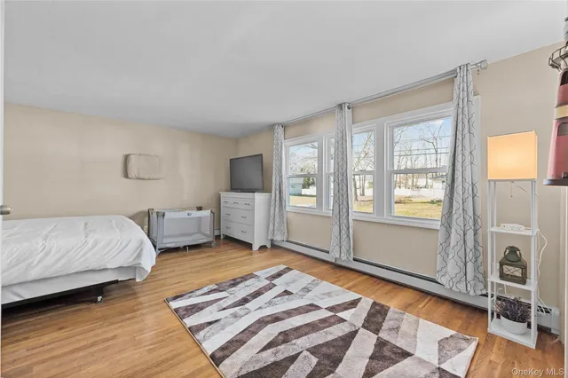 a spacious bedroom with a bed and wooden floor