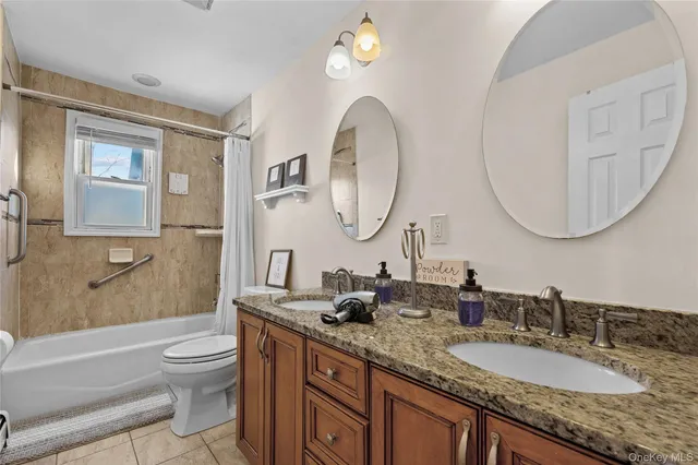 a bathroom with a granite countertop toilet a sink and a mirror