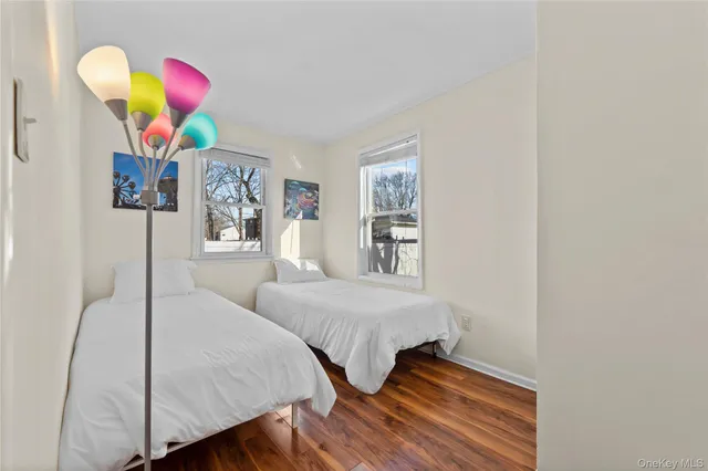 a bedroom with two beds and a painting on the wall