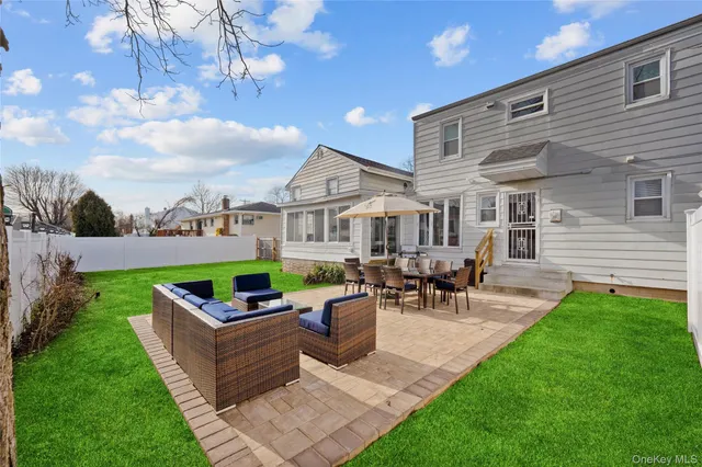 a view of a patio with couches and a table and chairs with plants and garden