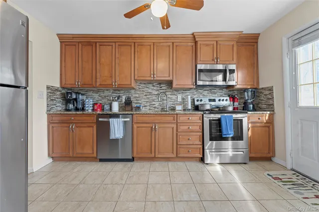 a kitchen with stainless steel appliances granite countertop a stove sink and cabinets