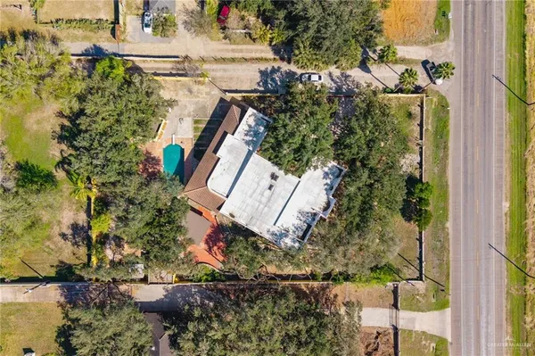 aerial view of a house with a yard and large trees