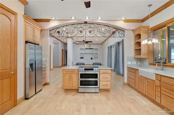 a large kitchen with stainless steel appliances a stove a refrigerator and a fireplace