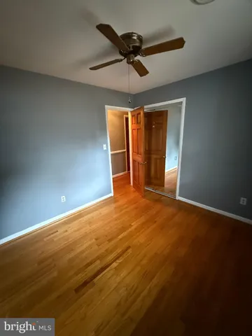 an empty room with a ceiling fan and window