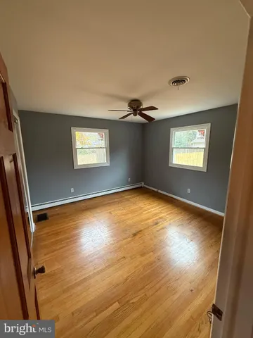 a view of empty room with window and wooden floor
