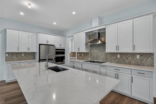 a kitchen with granite countertop a sink stainless steel appliances and cabinets