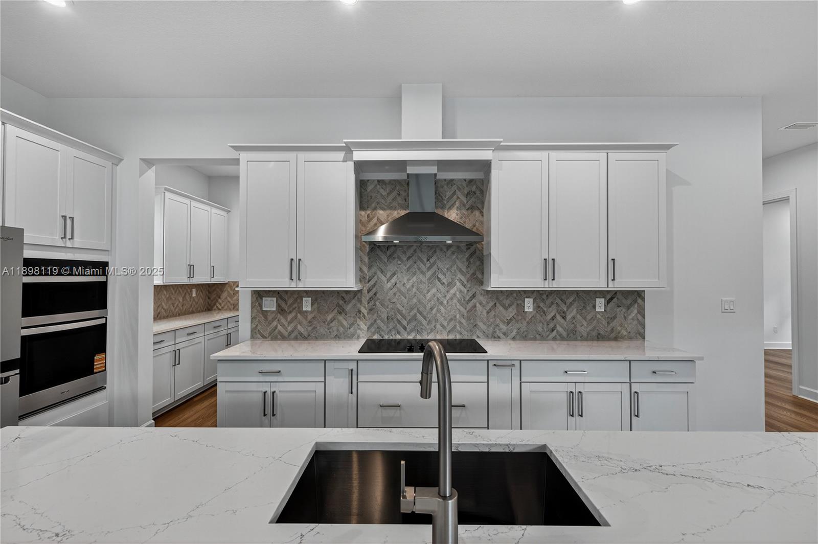 2722 Northwest 87th Terrace Cooper City, FL 33024 - Photo 16 of 44 a kitchen with granite countertop a stove top oven a sink a counter space and cabinets