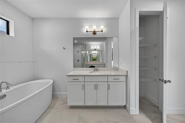 a bathroom with a granite countertop bathtub a sink and a mirror