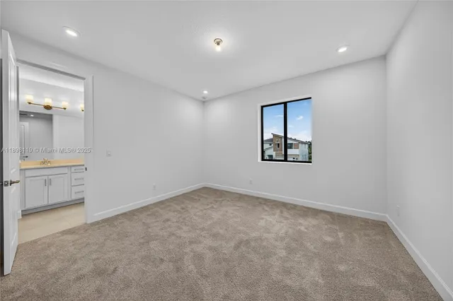 an empty room with a bathroom and a sink