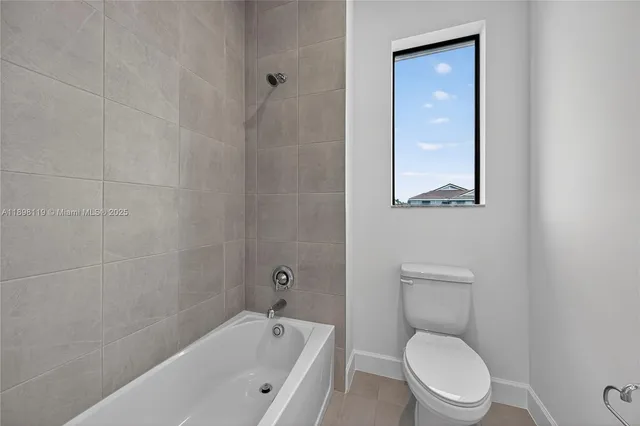 a white toilet sitting next to a bathtub