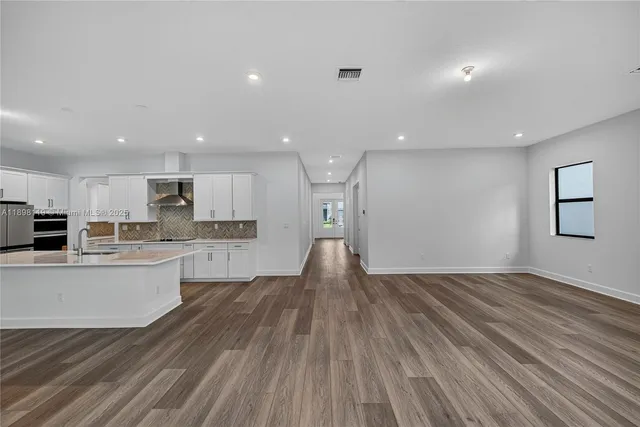 a view of kitchen with wooden floor and electronic appliances