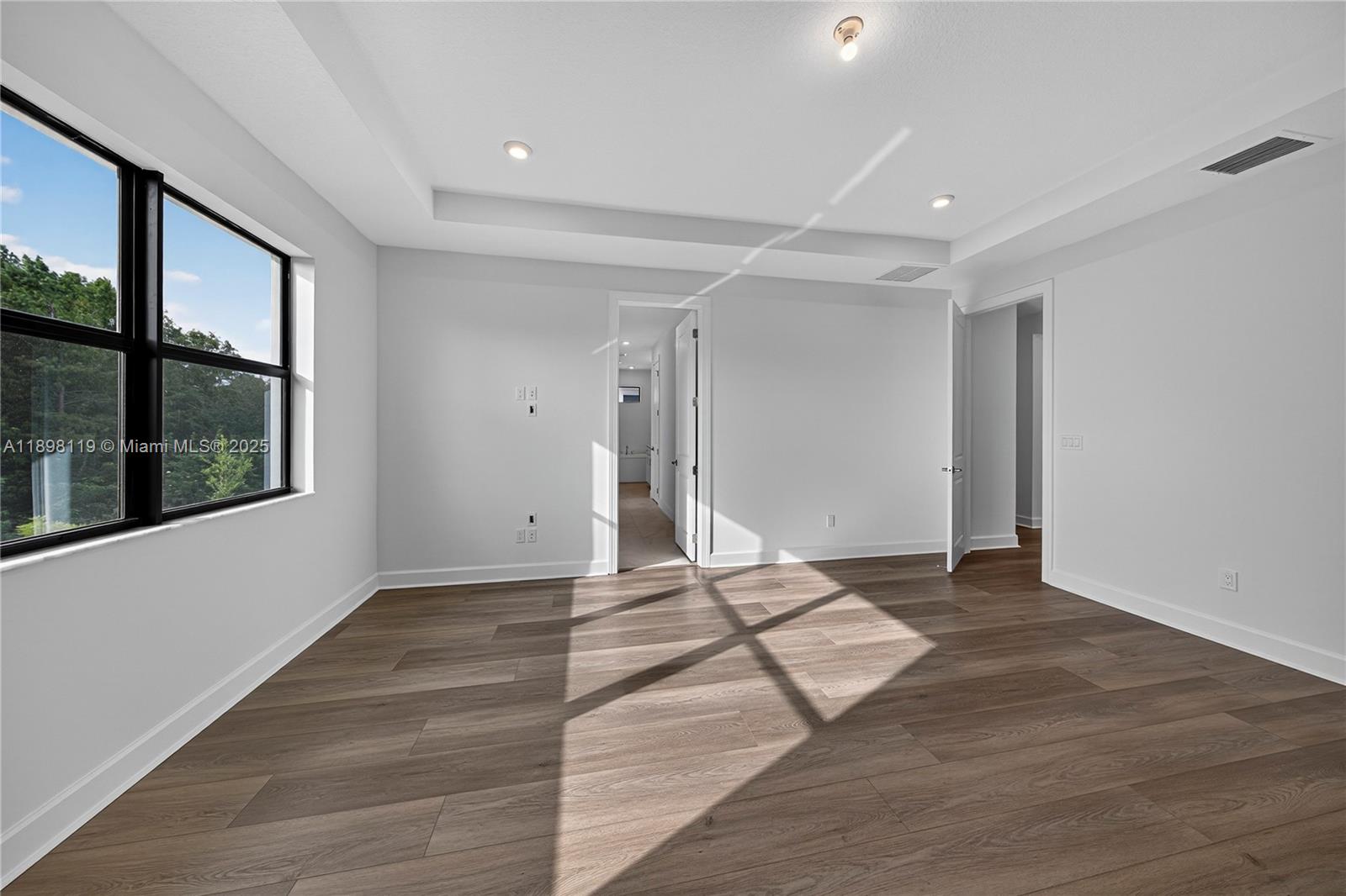 2722 Northwest 87th Terrace Cooper City, FL 33024 - Photo 8 of 44 a view of an empty room with wooden floor and a window