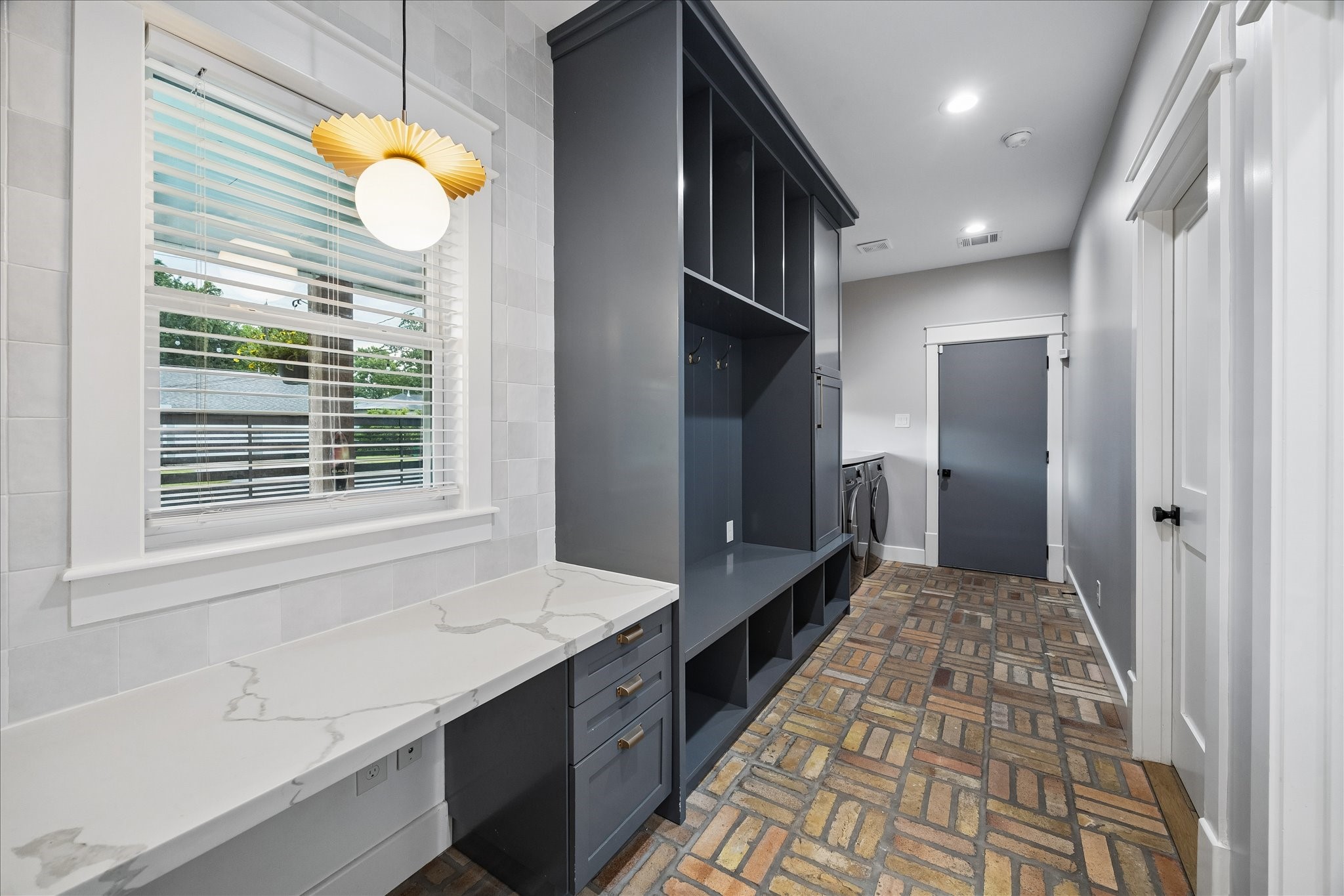 1205 Temple Street Houston, TX 77009 - Photo 29 of 33 Far more than a laundry room, this thoughtfully designed mudroom, utility space, back entry foyer with a built in desk space and brick floors offers custom built-ins, exceptional storage, and everyday organization that simplifies busy family life.