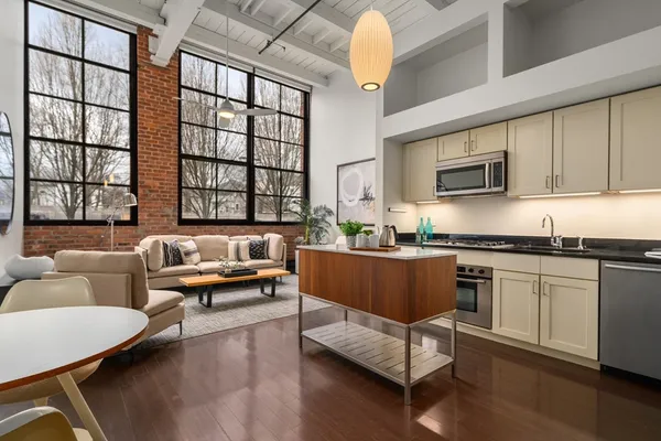 a living room with furniture and a kitchen area