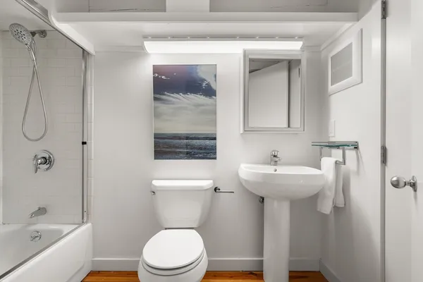 a bathroom with a sink a toilet and shower