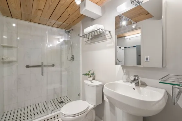 a bathroom with a sink a toilet and shower
