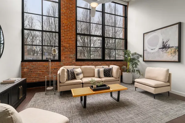 a living room with furniture a rug and a painting