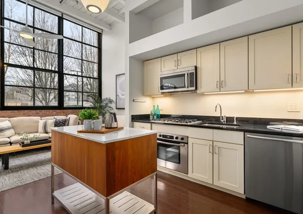 a kitchen with stainless steel appliances granite countertop a stove a sink and a microwave