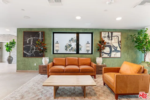 a living room with furniture a rug and a wall painting