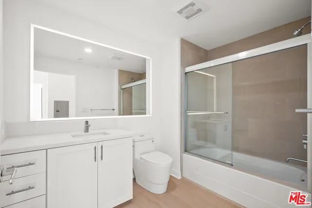 a bathroom with a bathtub shower sink vanity and toilet