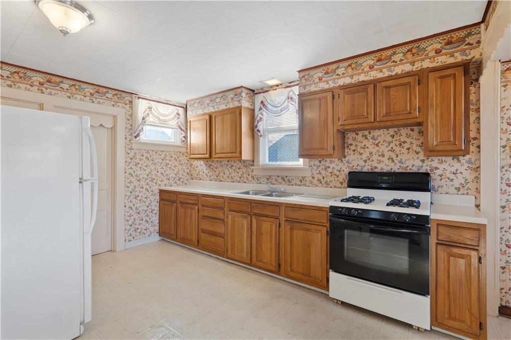 520 Center Street Rochester, PA 15074 - Photo 6 of 24 a kitchen with granite countertop a stove sink and cabinets