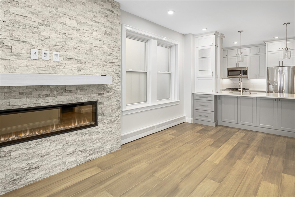 a view of kitchen with granite countertop fireplace and wooden floor