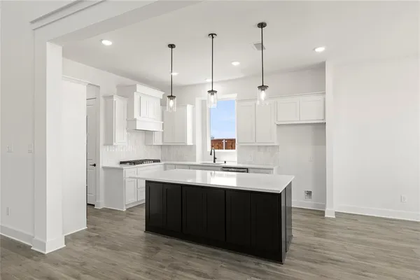 a kitchen with kitchen island a sink stainless steel appliances and cabinets