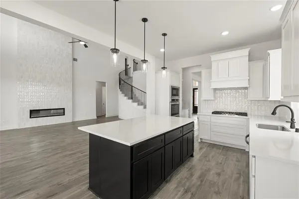 a kitchen with a sink a stove a refrigerator and white cabinets