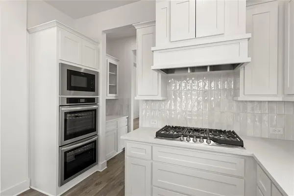 a kitchen with granite countertop stainless steel appliances and white cabinets