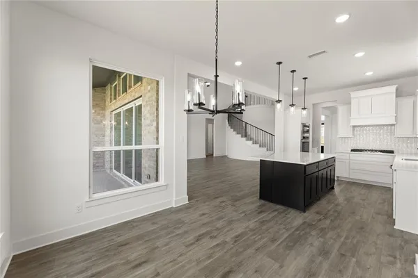 a view of kitchen with refrigerator stove and wooden floor